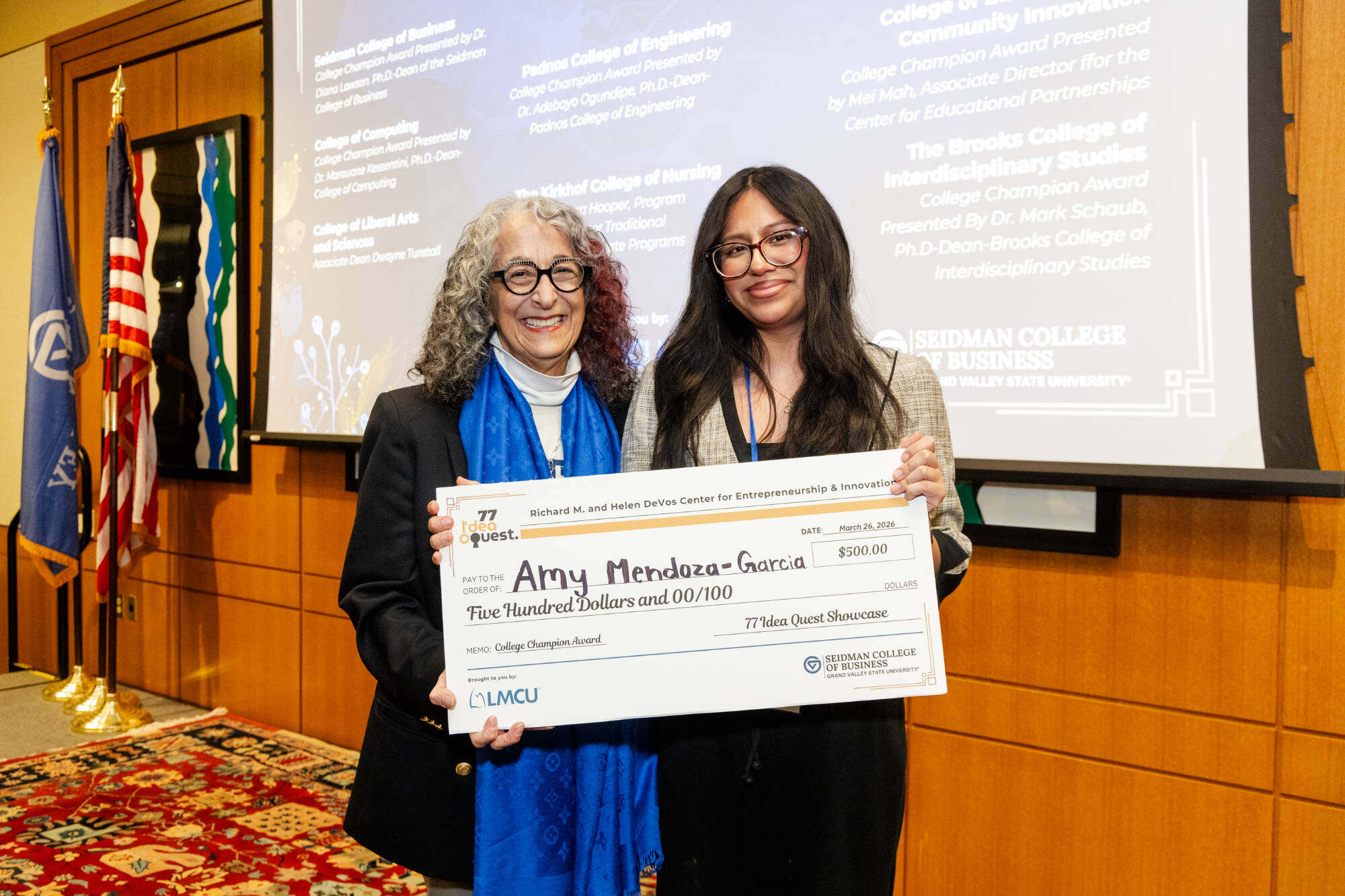 Student and Dean posing with the check for winning a College Champion award.